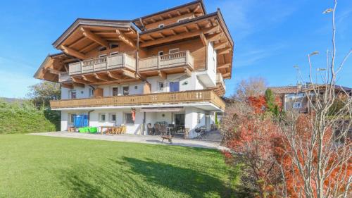 a large house with a dog in a yard at Appartementhaus Chalet Alpina in Sankt Johann in Tirol