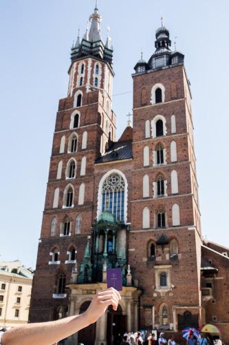 a person holding up a sign in front of a building at Balthazar Design Hotel in Kraków