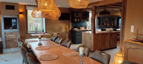 una sala da pranzo con tavolo e una cucina di B&B La Bouverie HF a Waimes