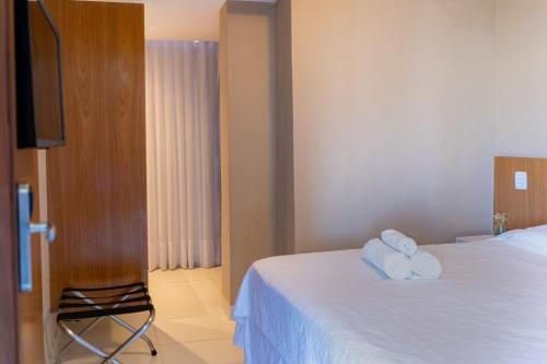 a hotel room with a bed with towels on it at Porto Suítes Natal Hotel in Natal