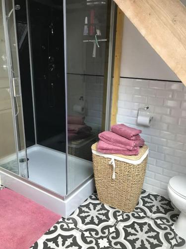 La salle de bains est pourvue d'une douche et d'un panier avec des serviettes. dans l'établissement Ferme de Noyes, à Sourdeval