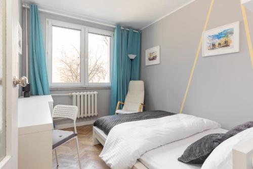 1 dormitorio con 2 camas y ventana en Krasiński Garden 2-bedroom Apartament, en Varsovia