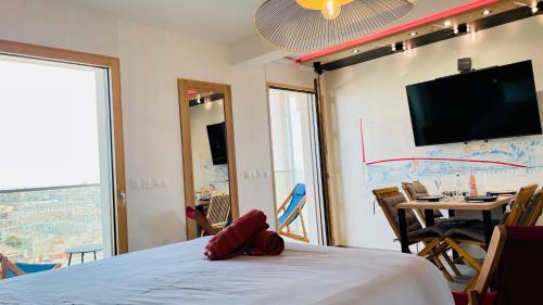 a room with a bed with a flat screen tv on the wall at Studio BEL-MOD BUGEY - Belvédère Moderne in Lyon