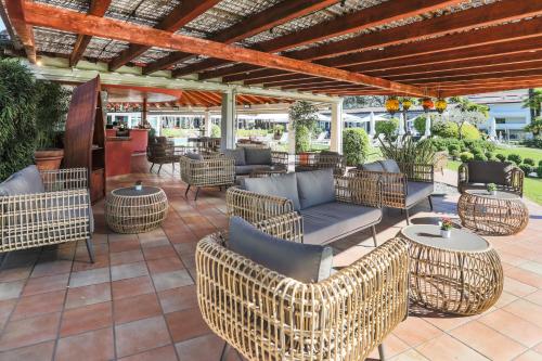 an outdoor patio with wicker chairs and tables at Villa Favorita - Parkhotel Delta in Ascona