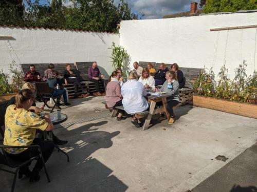 people are gathered around a table at Nexø Modern Hostel. Private Rooms in Neksø