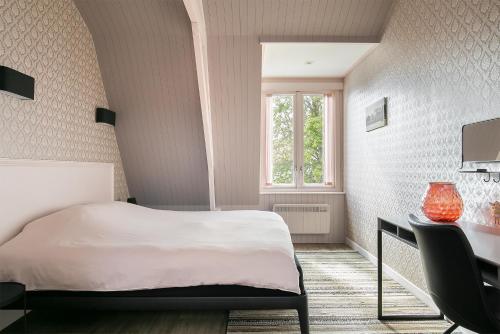 um quarto com uma cama, uma secretária e uma janela em Molepôlle 6 - Stadslogementen Franeker em Franeker