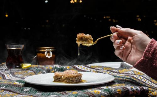 a person eating a piece of cake on a fork at Sheki Palace Hotel in Sheki
