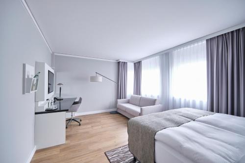 a bedroom with a bed and a desk and a chair at Holiday Inn Berlin Airport - Conference Centre by IHG in Schönefeld