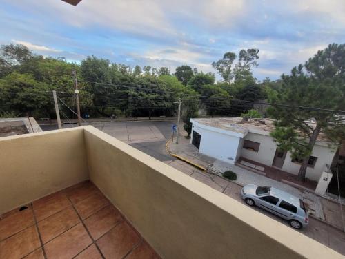 een balkon met uitzicht op een parkeerplaats bij Departamento Puerta del Rio in Villa María