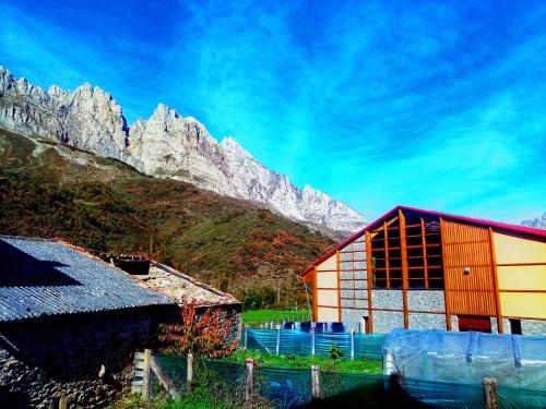 a barn with a mountain in the background at Casa Rural Burón in Posada de Valdeón