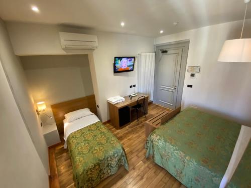 a hotel room with two beds and a desk at Artua'&Solferino in Turin