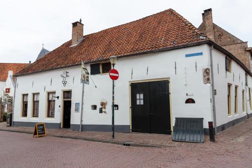 a white building with black doors on a street at Aparthotel Hattem in Hattem