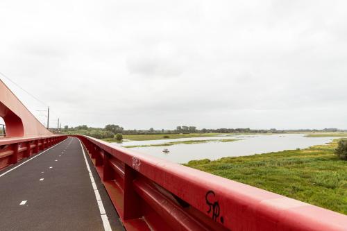 a red bridge with graffiti on it next to a river at Aparthotel Hattem in Hattem