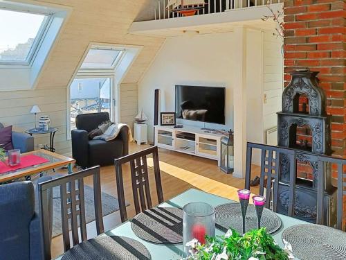 a living room with a table and a living room with a television at Seaside Fisherman s Haven-By Traum in Steinsbø