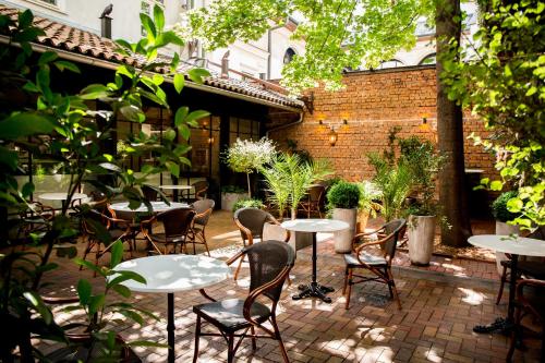 an outdoor patio with tables and chairs and plants at Balthazar Design Hotel in Kraków