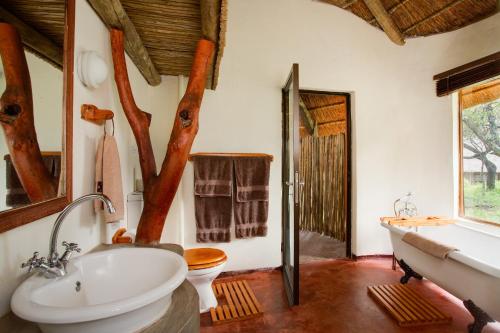 een badkamer met een bad, een wastafel en een toilet bij Warthogs Bush Lodge in Magaliesburg