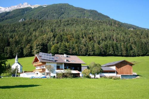 a house in a field next to a mountain at Veitnhof Vomperberg in Vomp