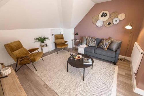 a living room with a couch and a table and chairs at BOURNECOAST: STYLISH FLAT WITH BALCONY - SEA VIEWS - PARKING - WIFI - FM8407 in Southbourne