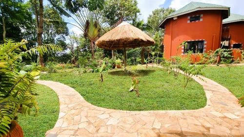 a brick path leading to a house with a straw umbrella at Africa Safari Arusha in Arusha
