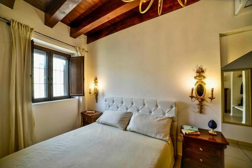 une chambre avec un lit, une fenêtre et un miroir dans l'établissement Syracusia, à Syracuse