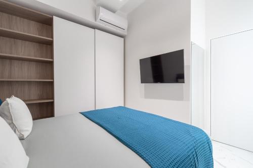 Schlafzimmer mit einem Bett und einem TV an der Wand in der Unterkunft Milano Duomo cozy apartment in Mailand