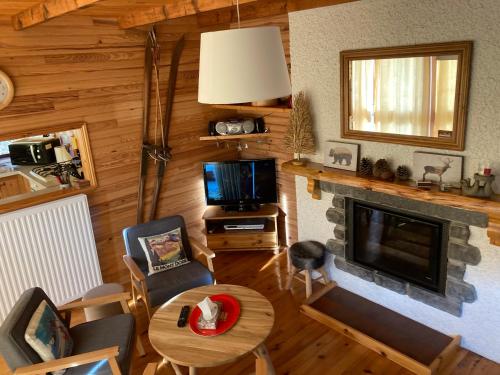 un salon avec une table et une cheminée dans l'établissement chalet le balcon du Sancy - location du samedi au samedi - linge de lits fournis - option ménage fin de séjour non proposée, à Le Mont-Dore
