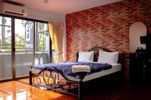 Cama en habitación con pared de ladrillo en Henry’s House, en Ban Ket Ho