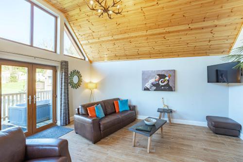 a living room with a couch and a tv at Kestrel Lodge 7 with Hot Tub in Newton Stewart