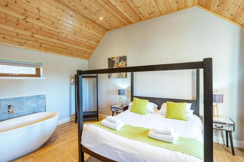 a bedroom with a large bed and a bath tub at Kestrel Lodge 7 with Hot Tub in Newton Stewart