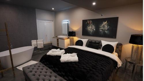 a bedroom with a large bed and a bath tub at Les Suites M in Wanze