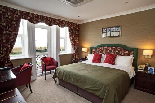 a bedroom with a large bed with red pillows at Imperial Hotel in Great Yarmouth