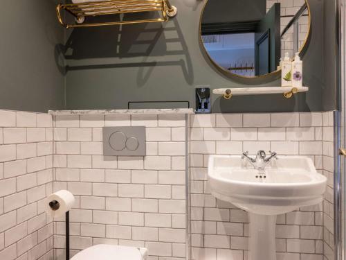 a white bathroom with a sink and a mirror at Spread Eagle in London