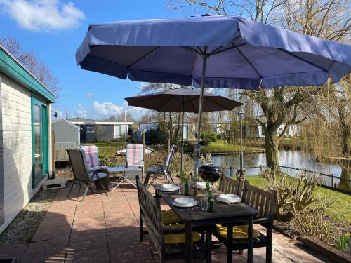 a patio with a table and an umbrella at Chalet Makkum T11 - vakantiehuisjemakkum nl in Makkum