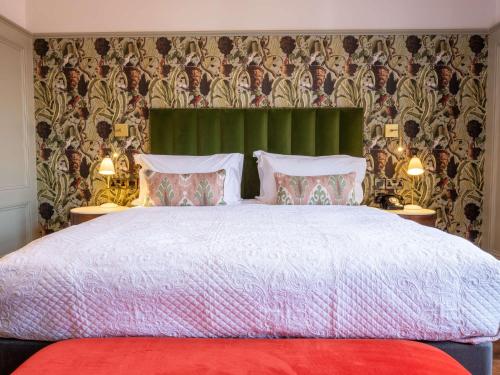 a bedroom with a large bed with a green headboard at Spread Eagle in London
