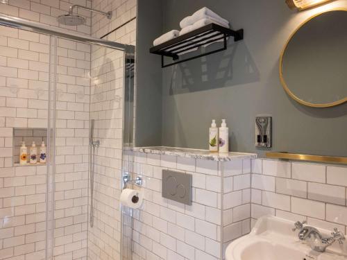 a bathroom with a shower and a sink and a mirror at Spread Eagle in London