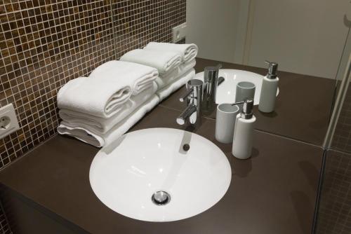 a bathroom with a white sink and towels on a counter at RAFAEL KAISER - Premium Apartments City Centre - Contactless Check-In in Vienna