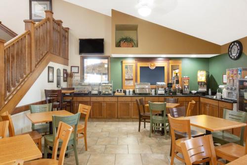 a restaurant with tables and chairs and a counter at AmericInn by Wyndham Muscatine in Muscatine