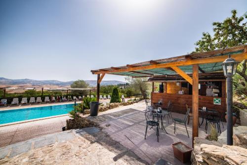 un patio con tavolo e sedie accanto alla piscina di Principe di Aragona ad Aragona