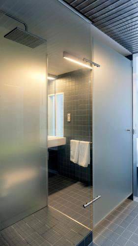 a shower with a glass door in a bathroom at Moure Hotel in Santiago de Compostela