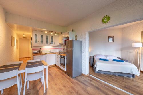 Il comprend une cuisine et une chambre avec un lit et une table. dans l'établissement Beautiful Studio With Garden Quiet Area, à Saint-Gervais-les-Bains