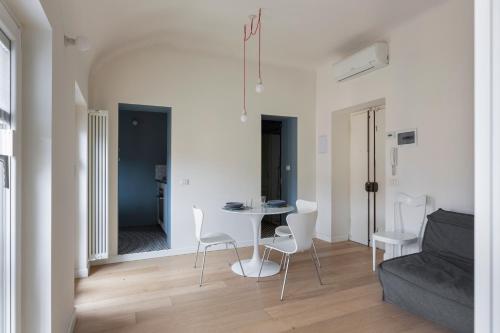 een woonkamer met een tafel en stoelen en een bank bij Luce Suit - your windows on the city Milano in Milaan