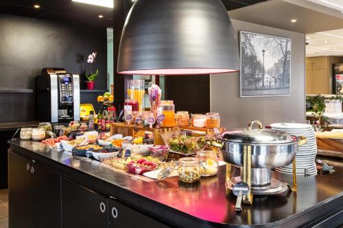 a buffet of food on a counter in a kitchen at Campanile Arras - Saint-Nicolas in Saint-Nicolas