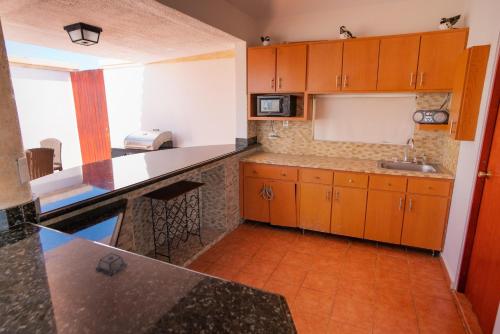 a kitchen with wooden cabinets and a counter top at Costa Ensenada Penthouse 505 across the street from Balneario beach in Rincon