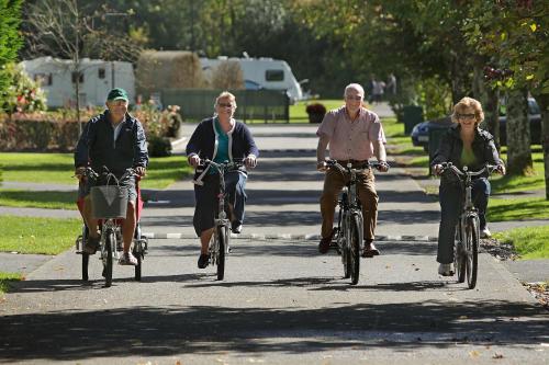 a group of people riding bikes down a street at Flemings White Bridge Self-Catering Mobile Home Hire in Killarney