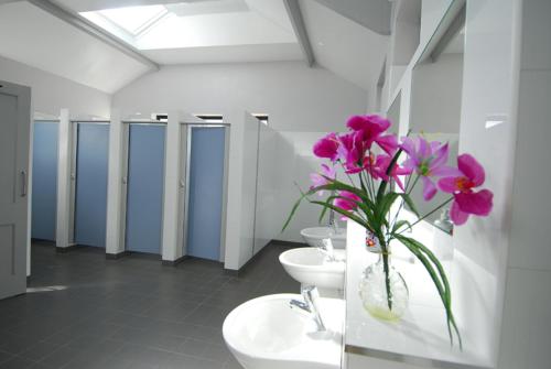 a bathroom with two sinks and a vase with purple flowers at Flemings White Bridge Self-Catering Mobile Home Hire in Killarney
