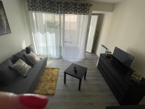 a living room with a couch and a tv at JC Appart in Millau