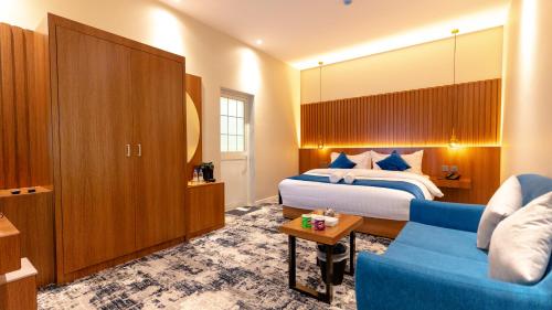een hotelkamer met een bed en een blauwe bank bij فندق ارجان بارك Arjan Park Hotel in Wadi ad-Dawasir