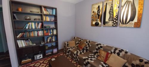 a living room with a couch and a book shelf at Mainalo View House in Vitina