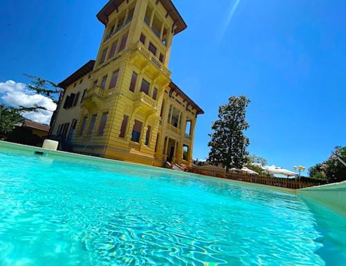 a building with a clock tower behind a pool of water at Villa Moorings in Barga