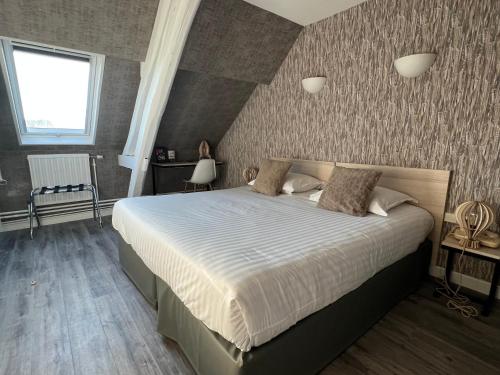 een slaapkamer met een groot bed in een kamer bij Hôtel De Troyes in Troyes